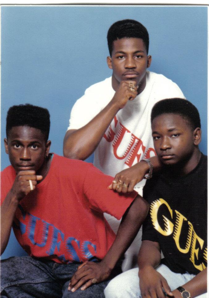 3 black men, probably brothers posing for their family photo